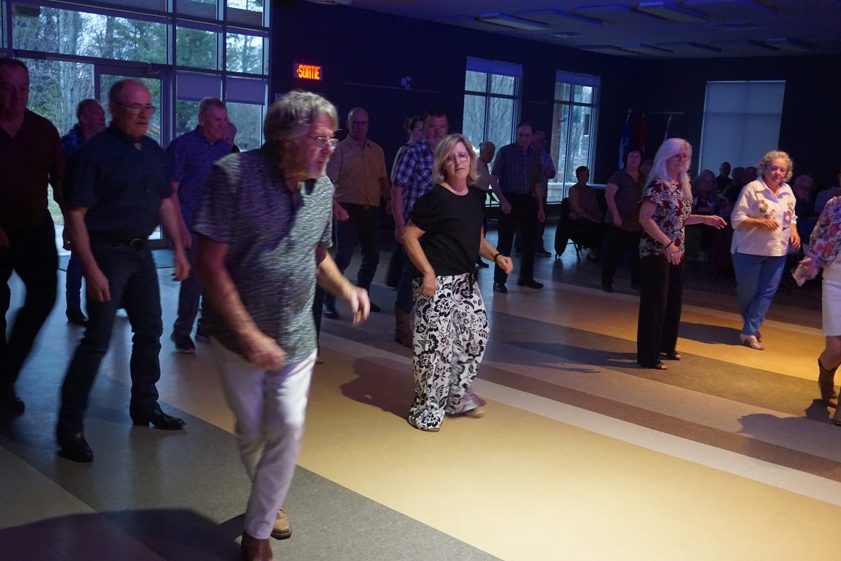 Danse en ligne en soirée, salle éclairée aux couleurs